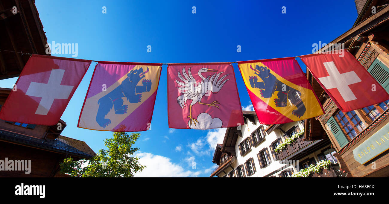 Swiss flag in old city center of Gstaad town, famous ski resort in canton Bern, Switzerland. Stock Photo