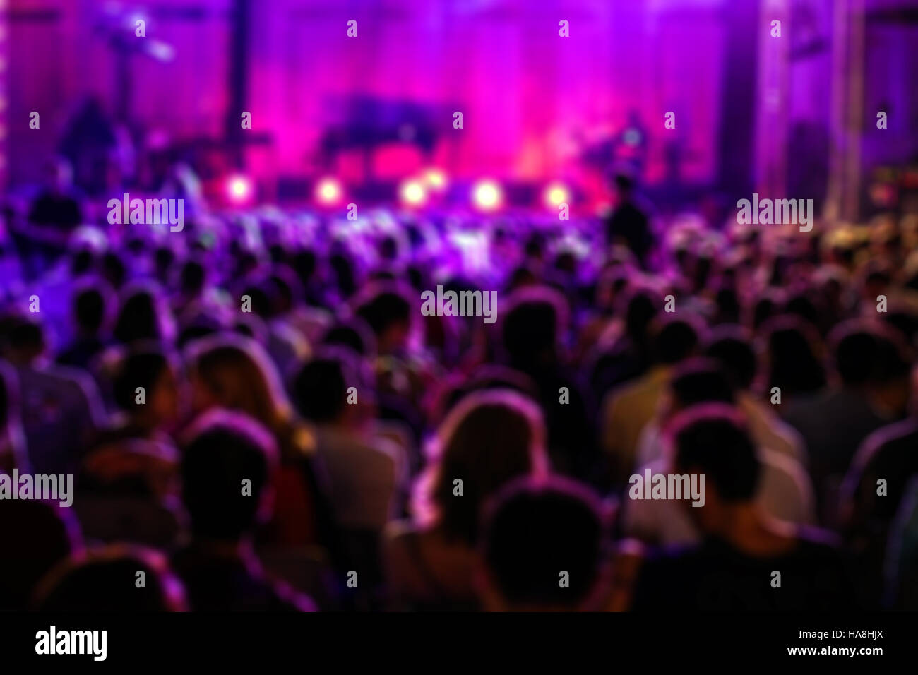 Blurred Image of People at Music Concert, with purple lights Stock Photo