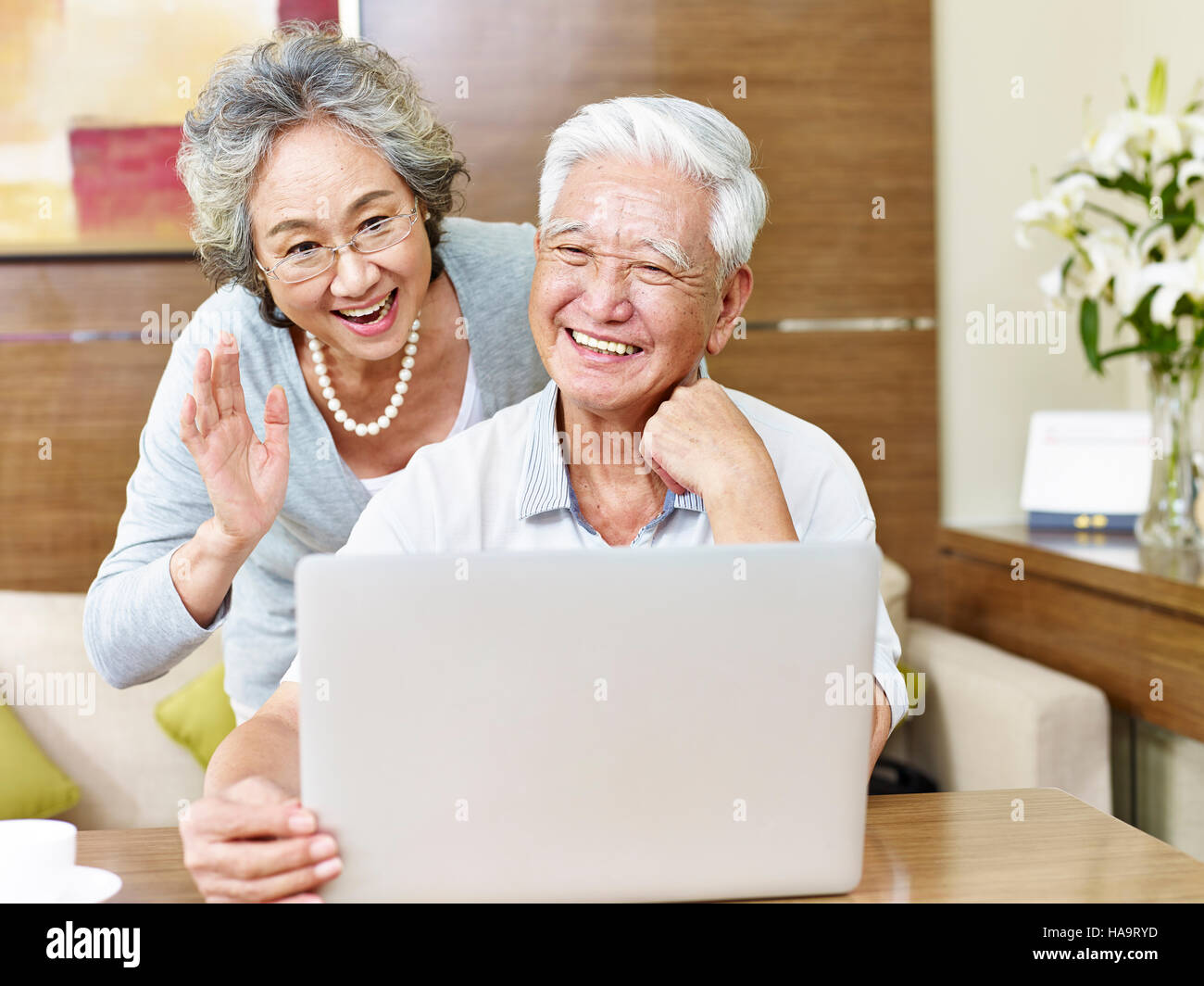 senior asian couple saying hello during a video chatting. Stock Photo