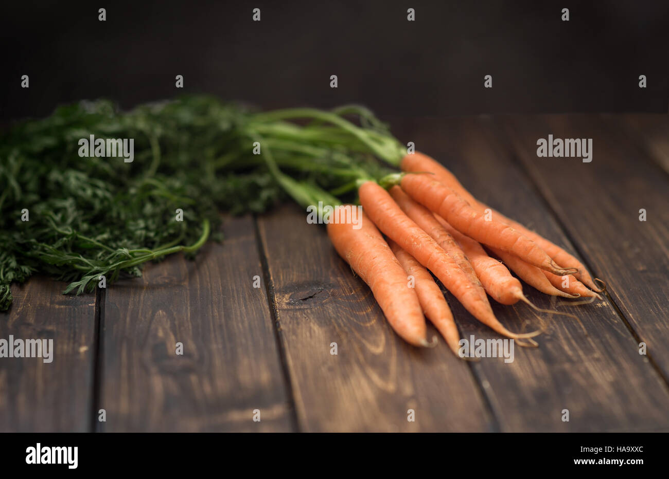 Carrot with green leaves on rustic table Stock Photo Alamy