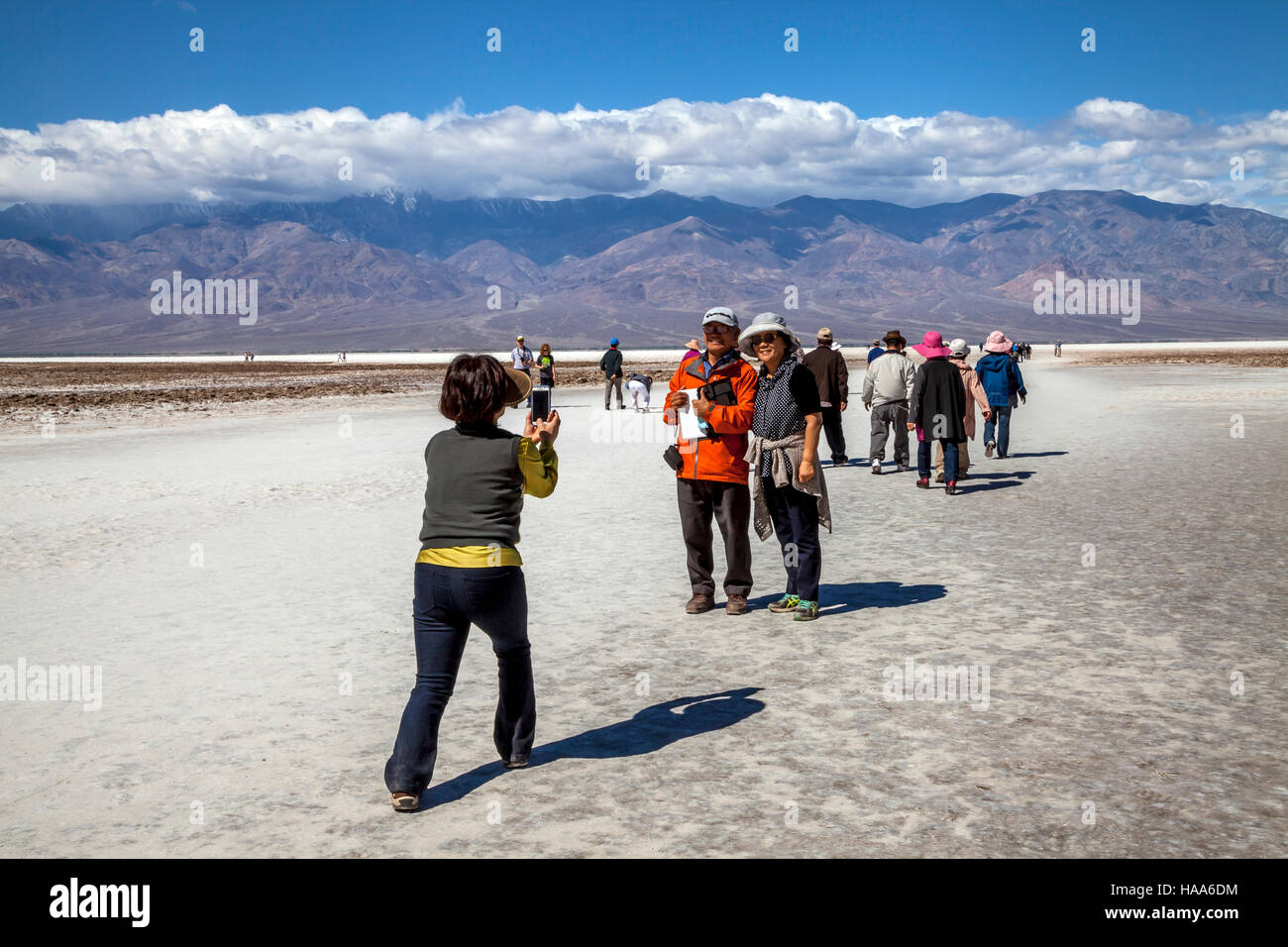 Asian woman taking pictures of her friends, Badwater Basin, Death Valley National Park, California, USA Stock Photo