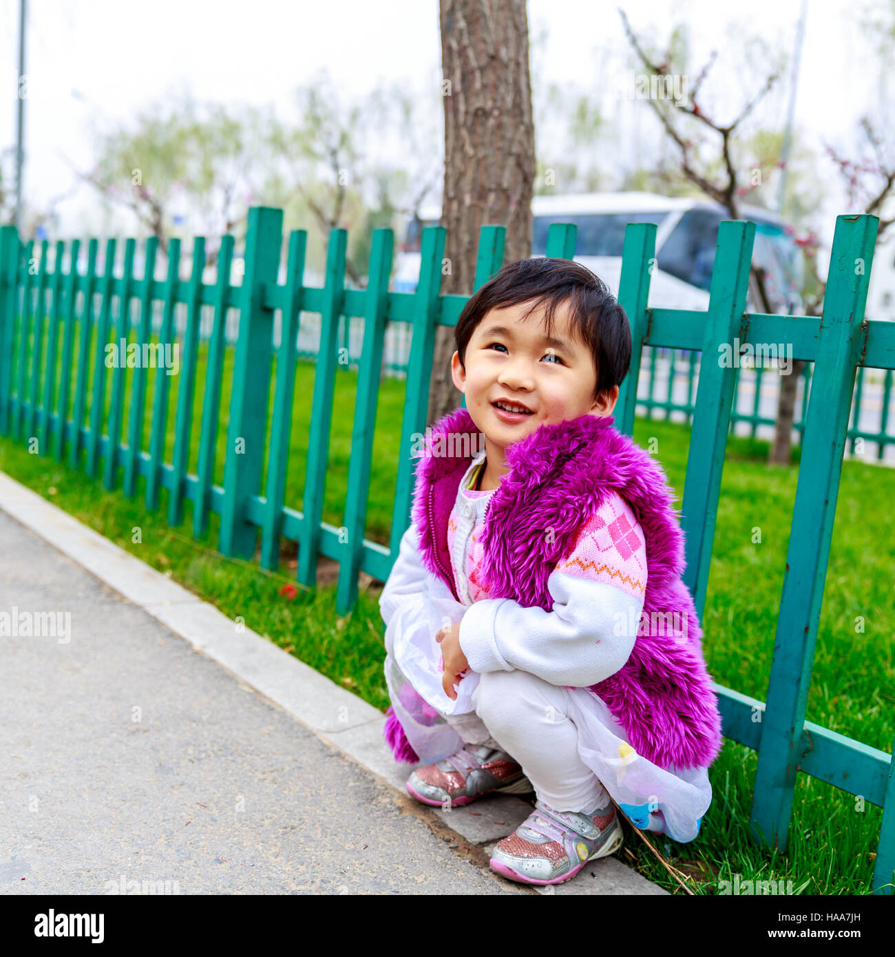 Adorable girl enjoys play time on the street, smiling. Stock Photo