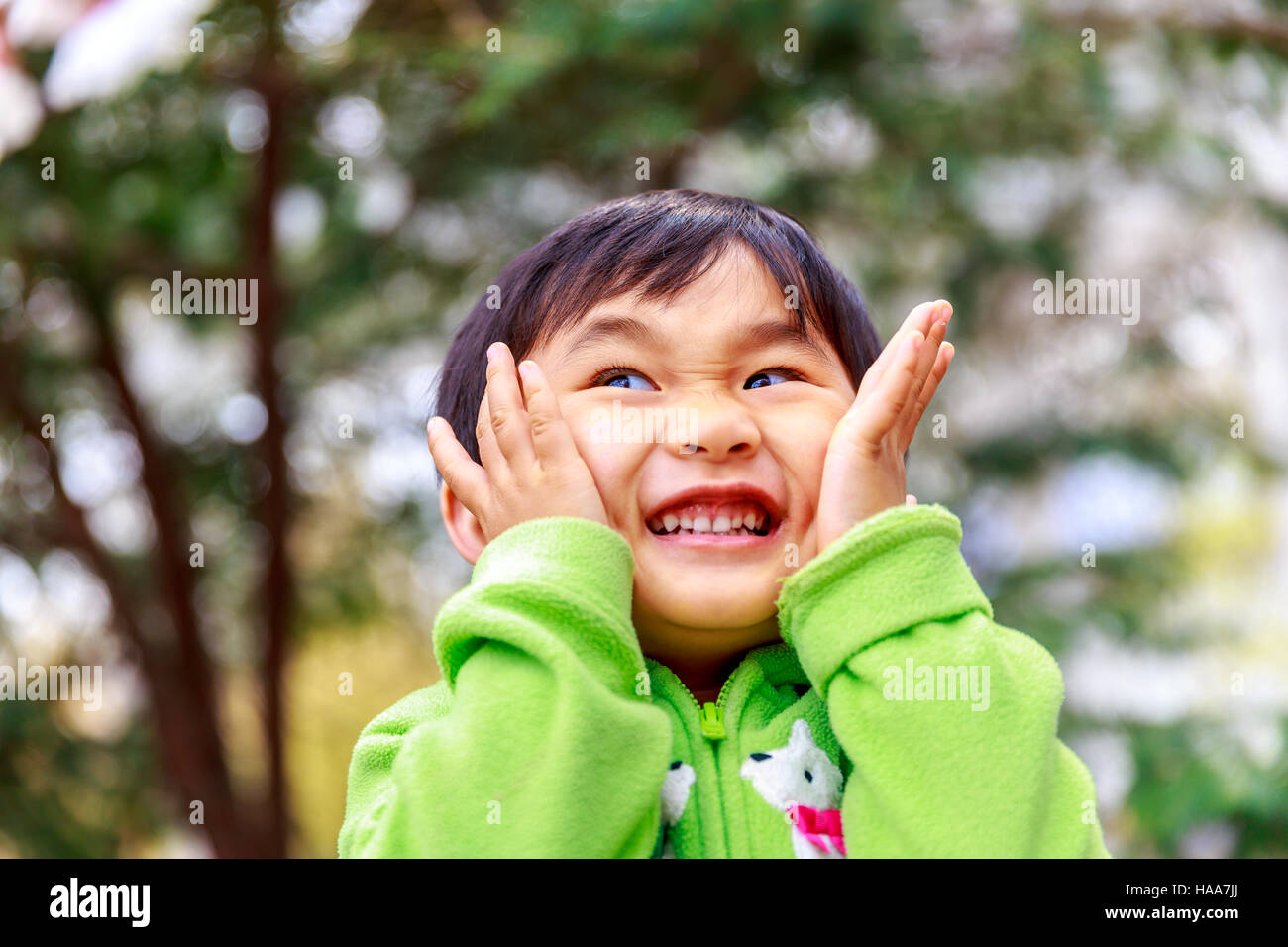 Adorable girl enjoys play time in the woods, smiling. Stock Photo