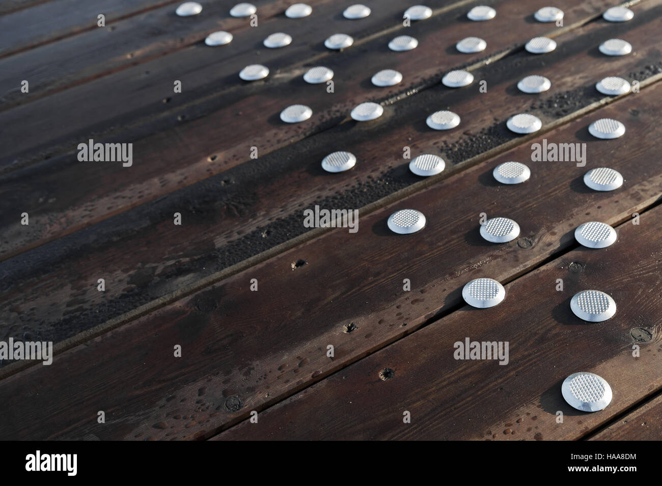 Outdoor wooden flooring with steel anti-slip buttons Stock Photo