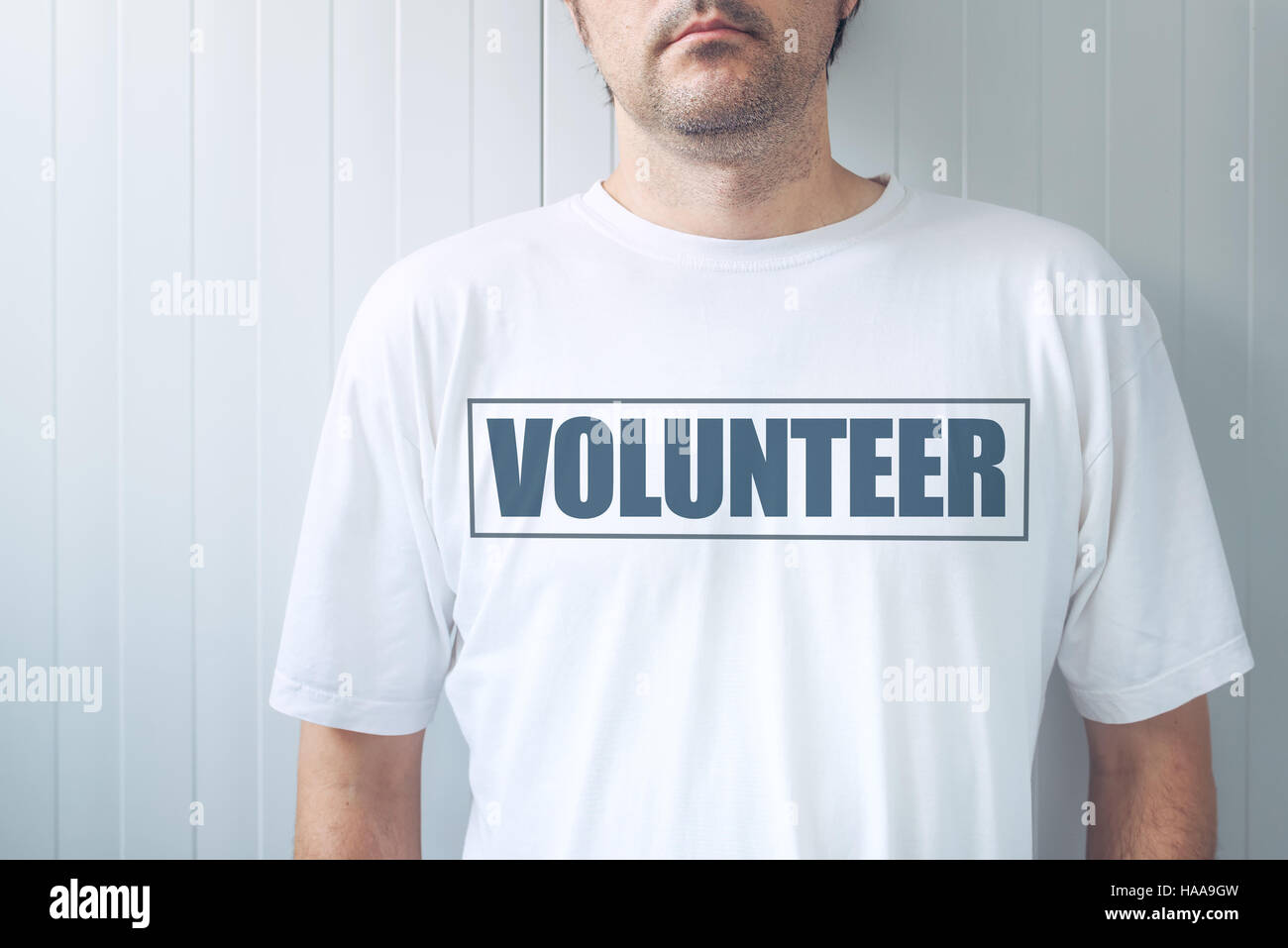 Guy wearing shirt with Volunteer label printed on chest, confident friendly person offering help Stock Photo