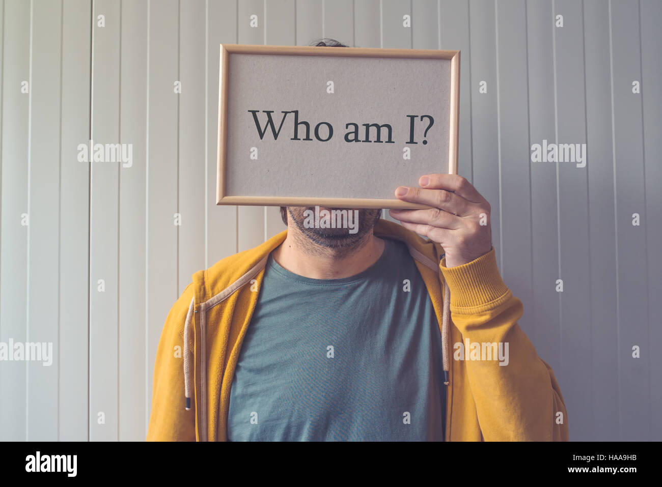 Who am I, self-knowledge concept with question covering adult male face Stock Photo