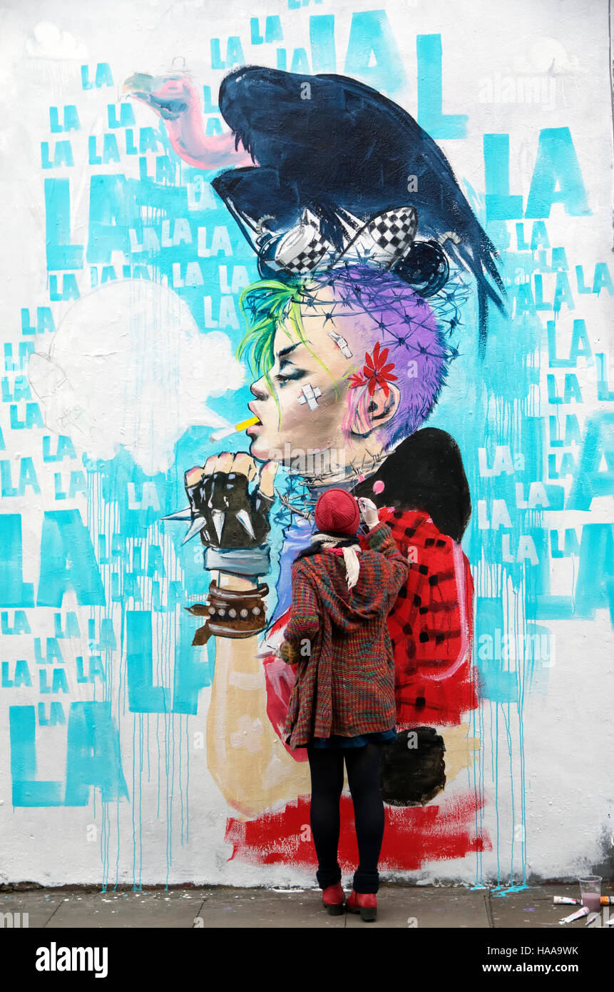 Artist - Lora Zombie - working on graffiti in Hanbury Street off London's Brick Lane Stock Photo