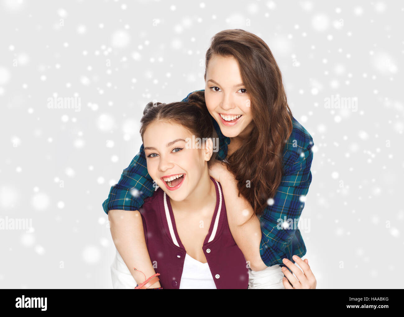happy smiling teenage girls hugging over snow Stock Photo - Alamy