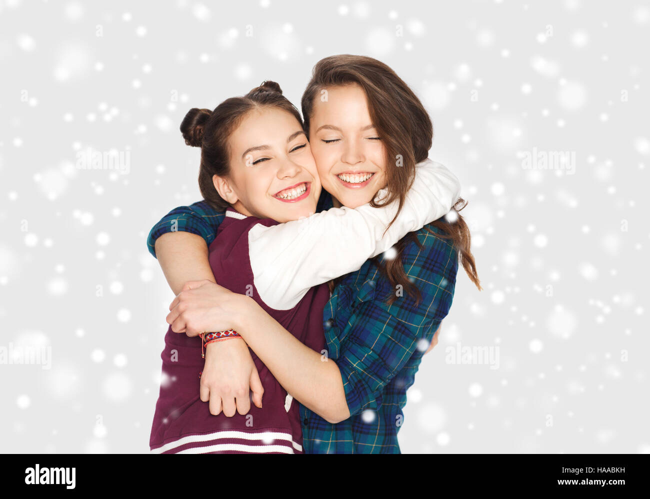 happy smiling teenage girls hugging over snow Stock Photo - Alamy