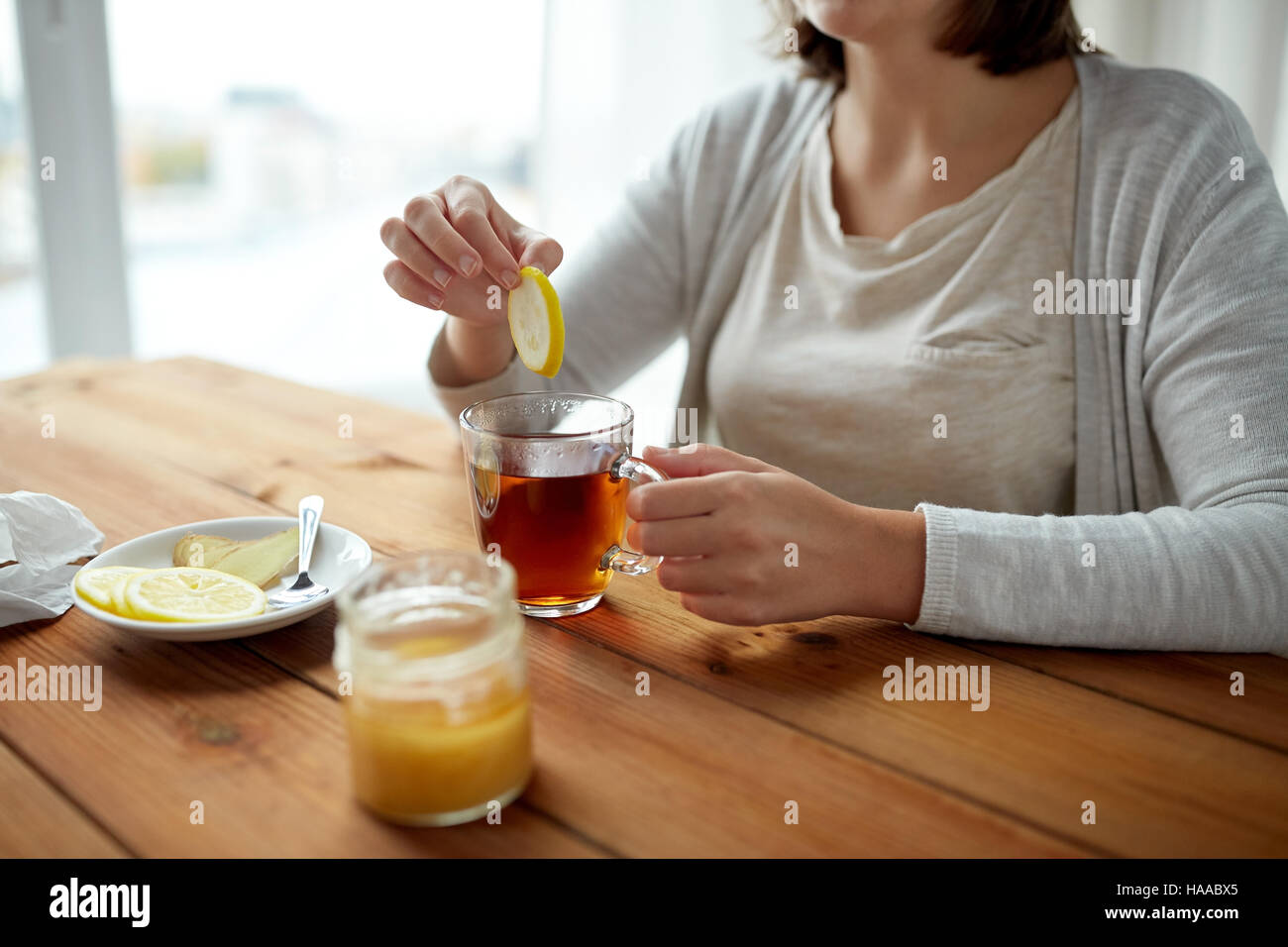Close up of woman adding lemon to tea cup stock photo alamy