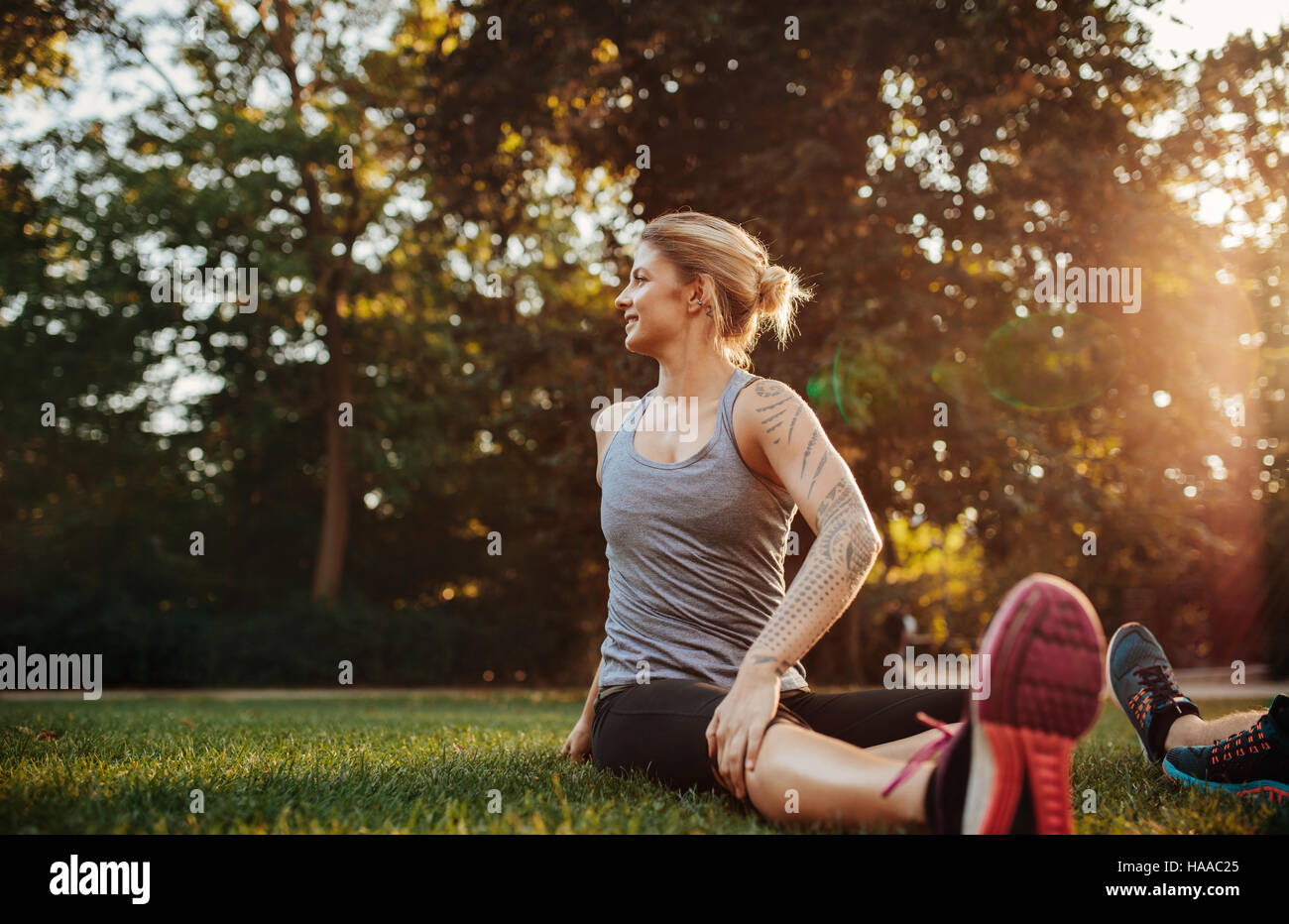Fit young woman exercising at park. Fit young woman doing stretching workout in morning. Stock Photo