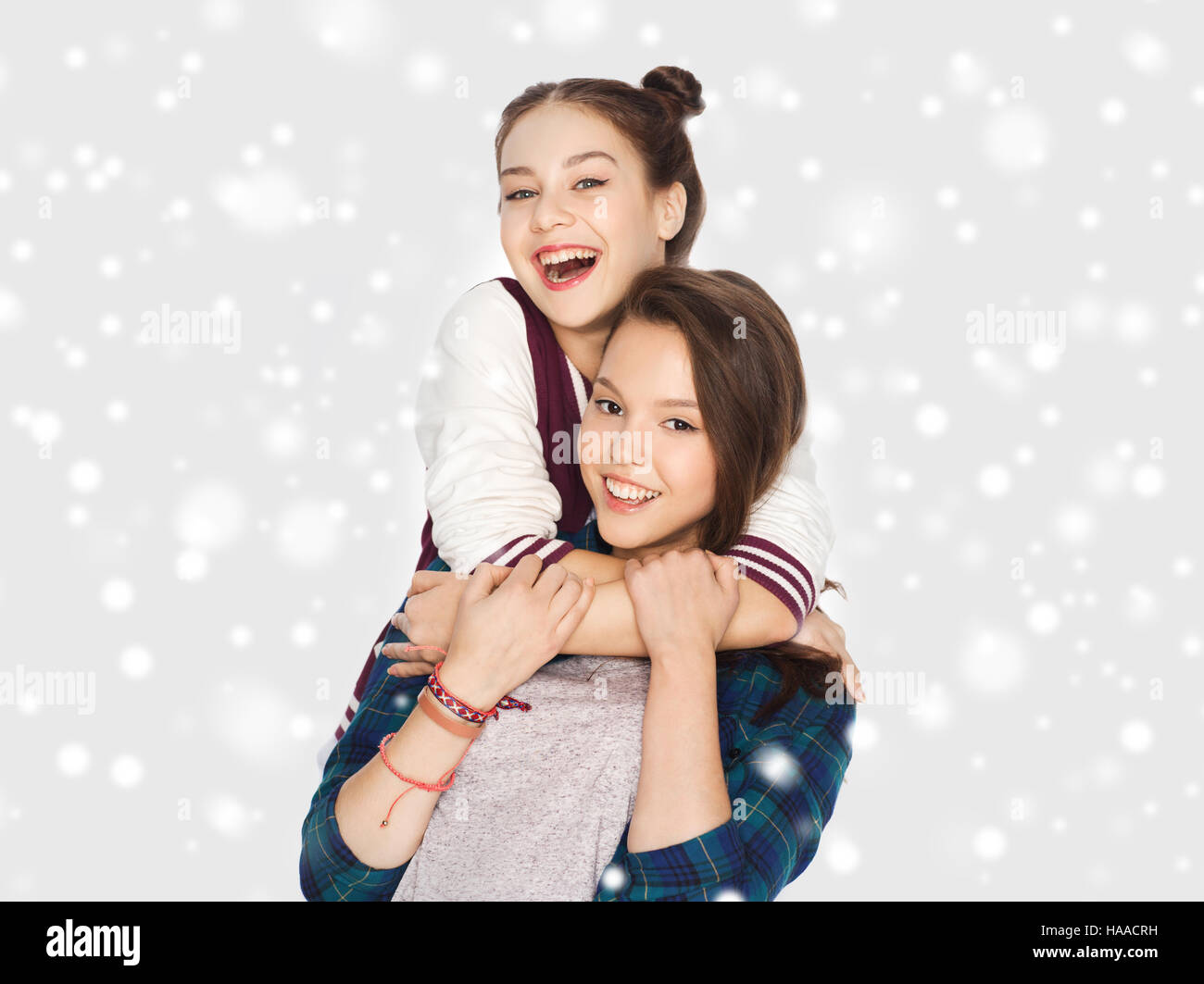 happy smiling teenage girls hugging over snow Stock Photo - Alamy