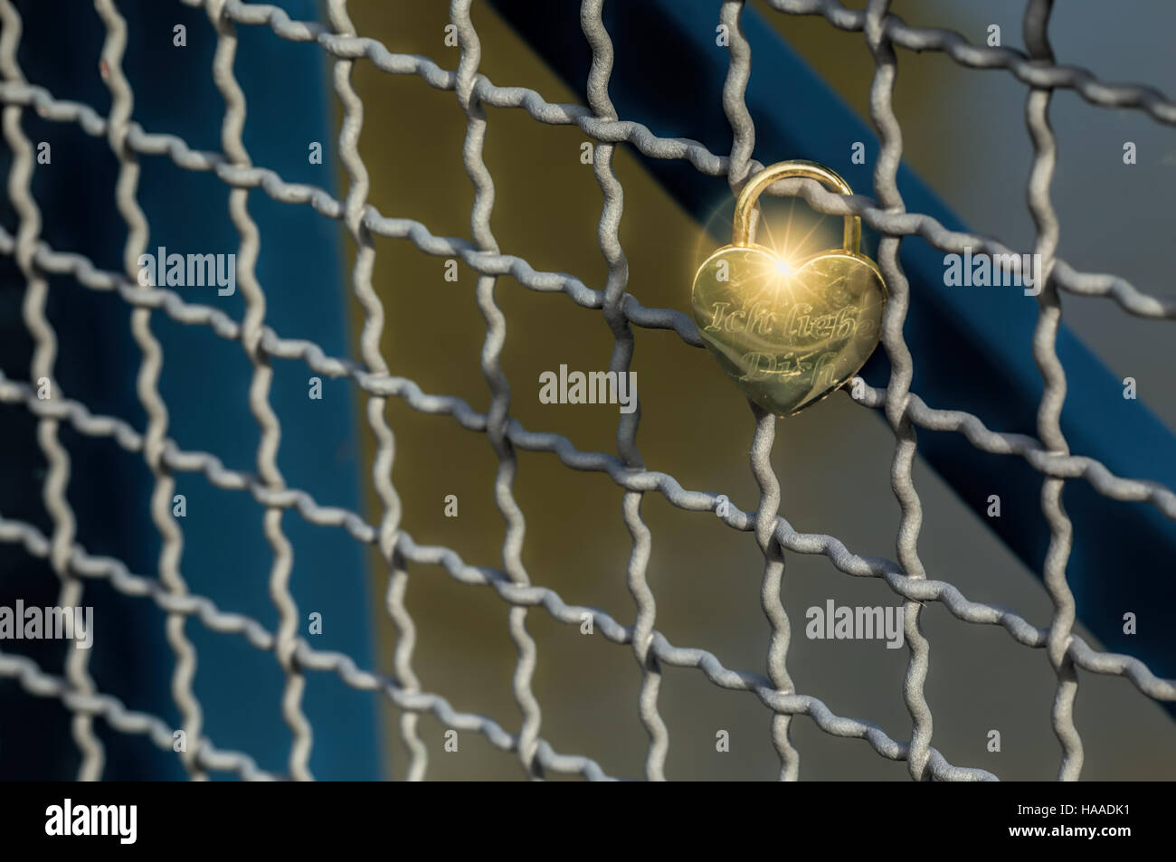 Heart shaped love padlock attatched to wire fence on a bridge. The ...