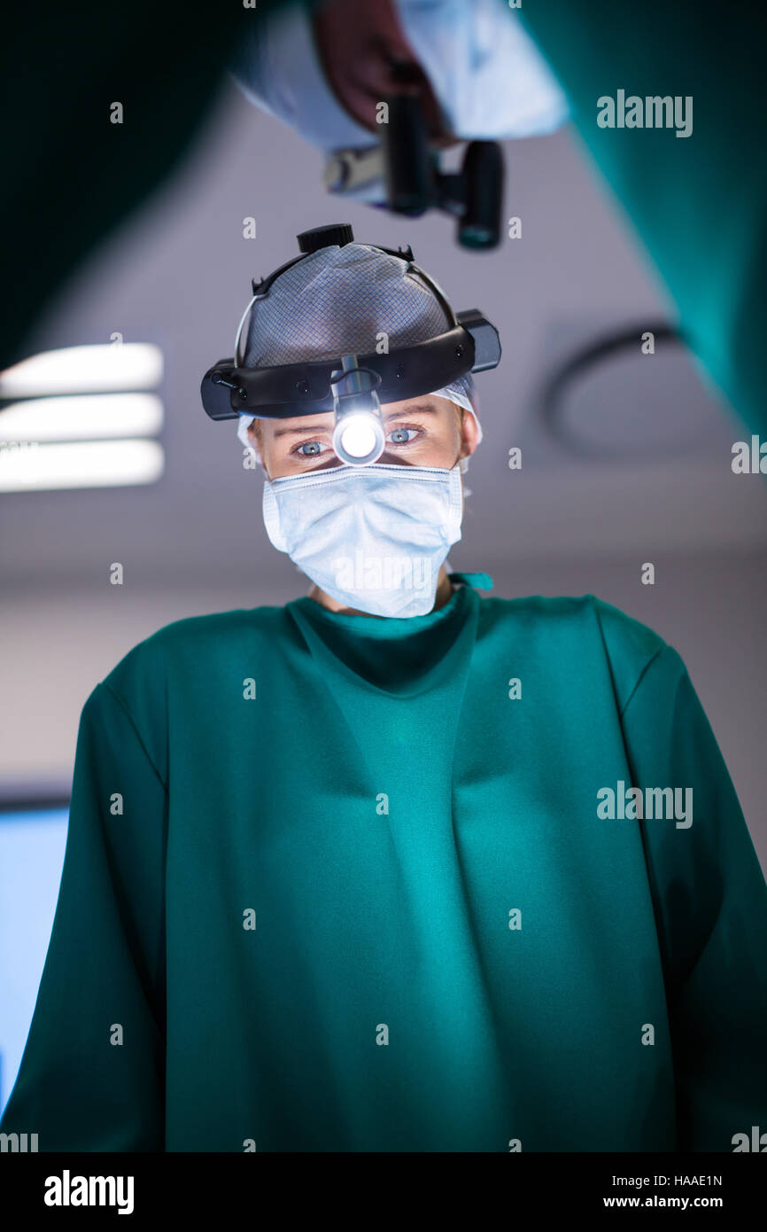 Surgeons wearing surgical loupes while performing operation Stock Photo