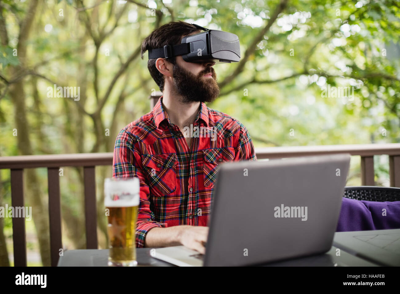 Man using virtual reality headset while using laptop Stock Photo - Alamy
