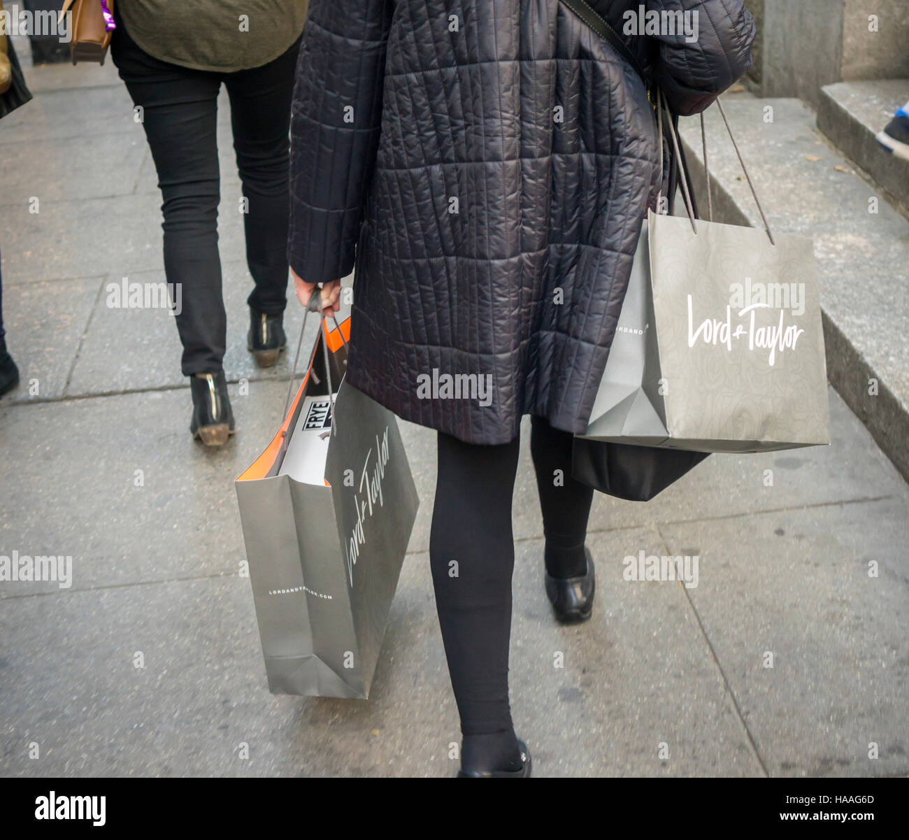 A shopper laden with her Lord & Taylor purchases in New York on Sunday, November 20, 2016. As shoppers turn to online shopping and stores expand their opening hours into Thanksgiving fewer shoppers flocking to the stores on Friday. (© Richard B. Levine) Stock Photo