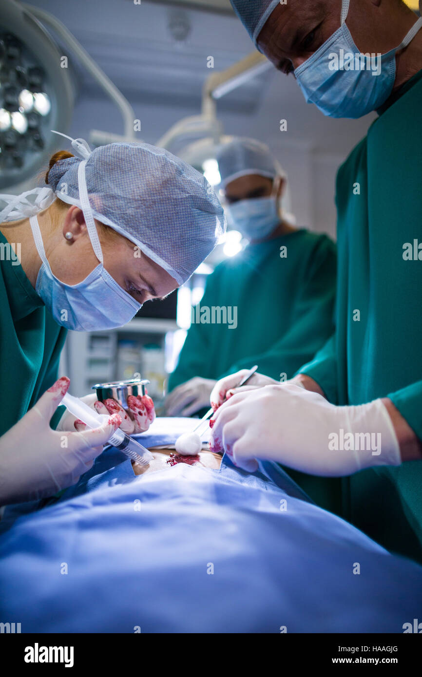Surgeons performing operation in operation theater Stock Photo