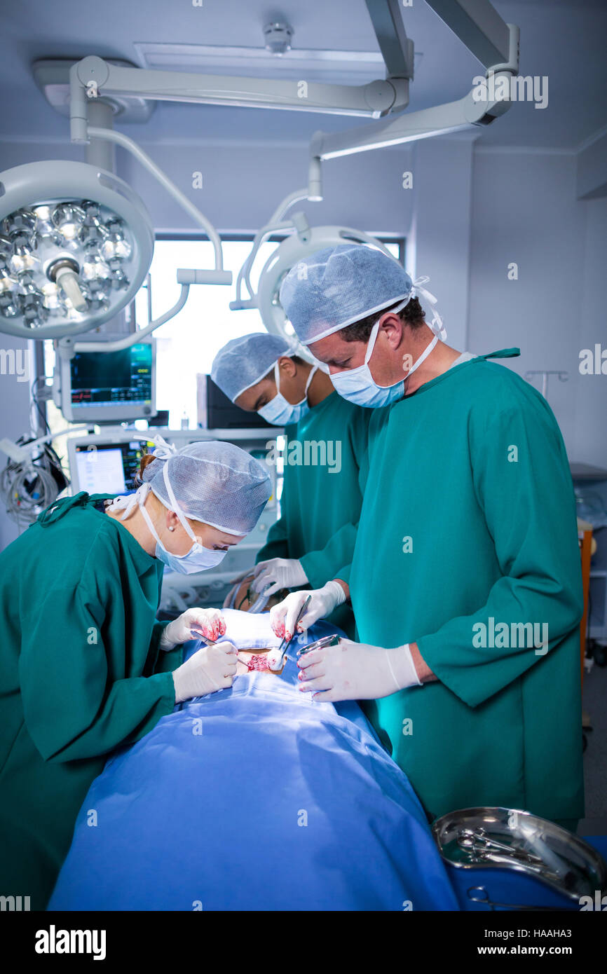 Surgeons performing operation in operation theater Stock Photo