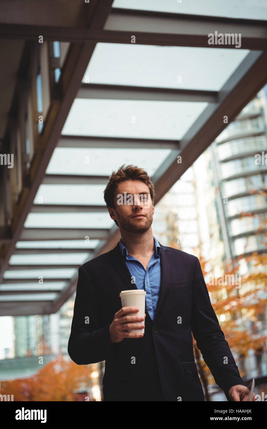 Businessman holding disposable coffee cup and digital tablet Stock ...