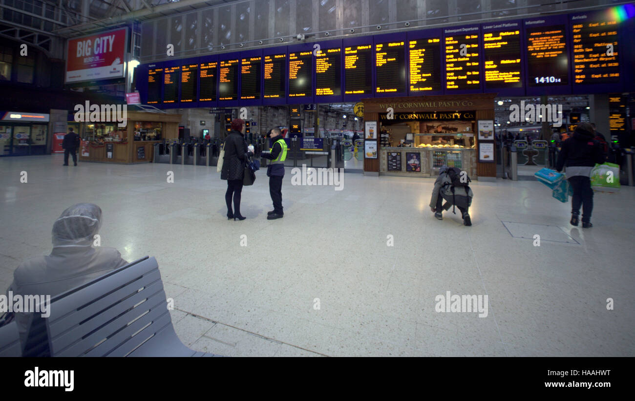 Family in Glasgow central train station phoning looking arrivals board Stock Photo