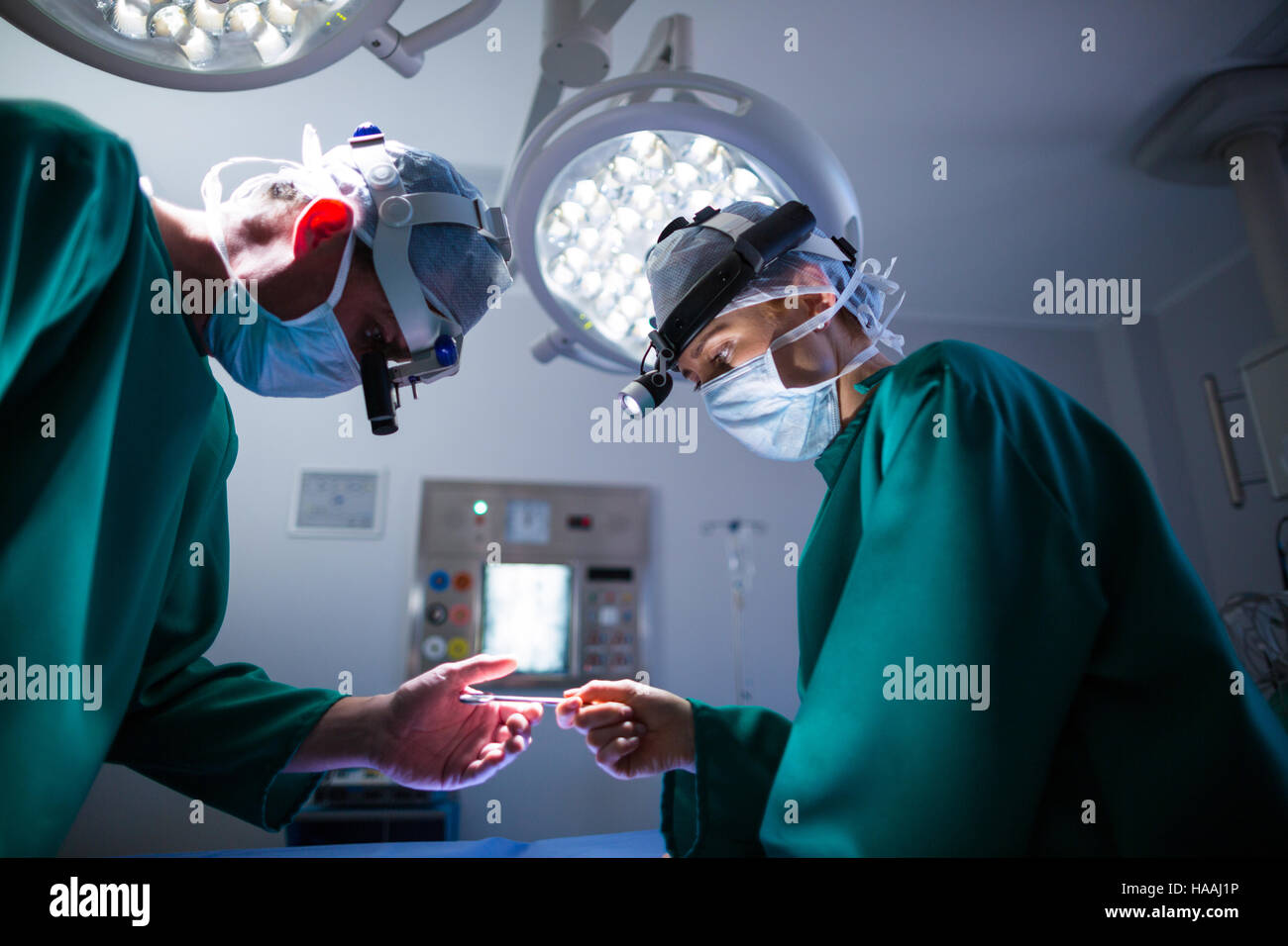 Surgeons wearing surgical loupes while performing operation Stock Photo