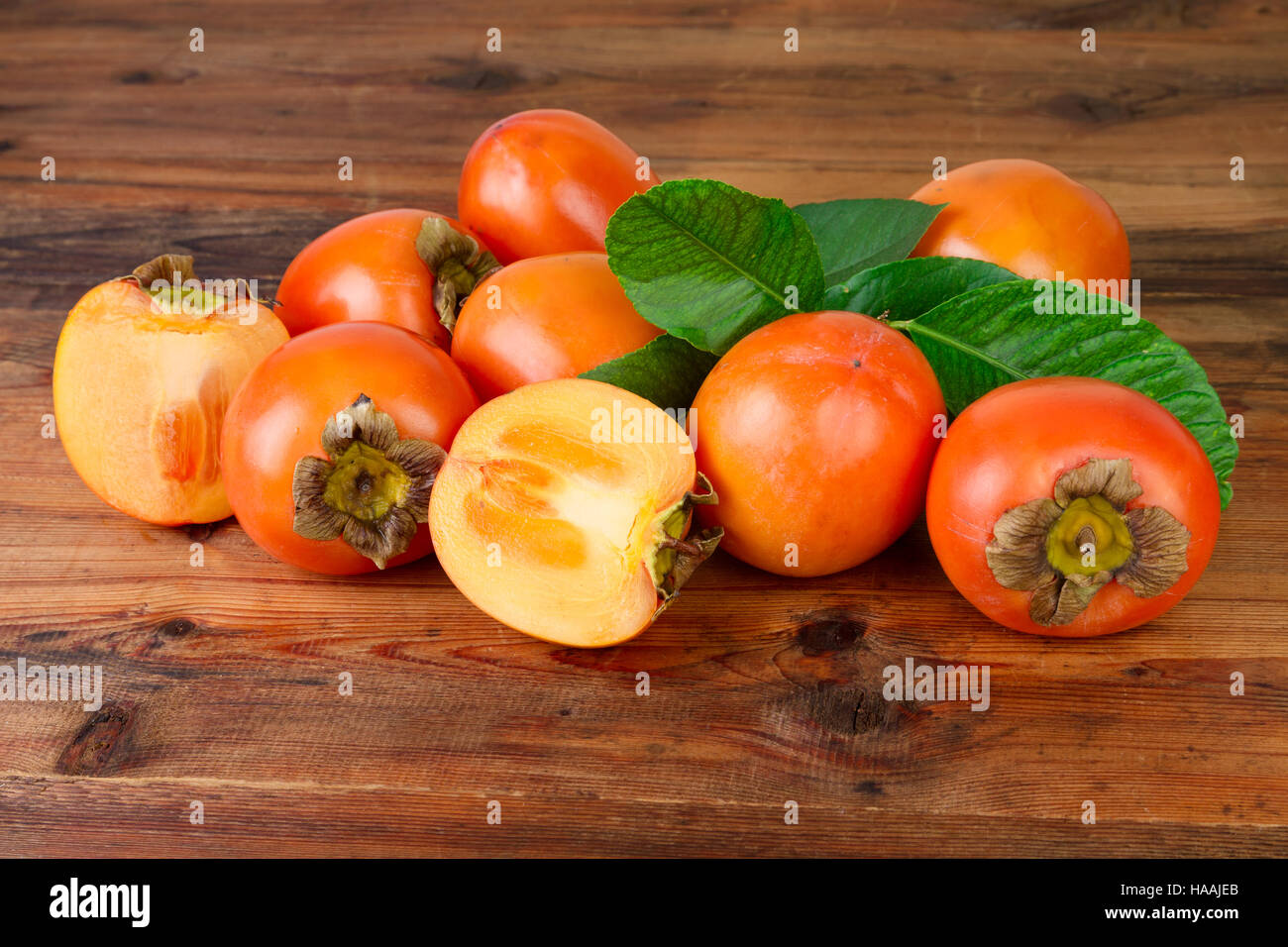 Persimmon. Kaki fruits on old wooden background. Stock Photo