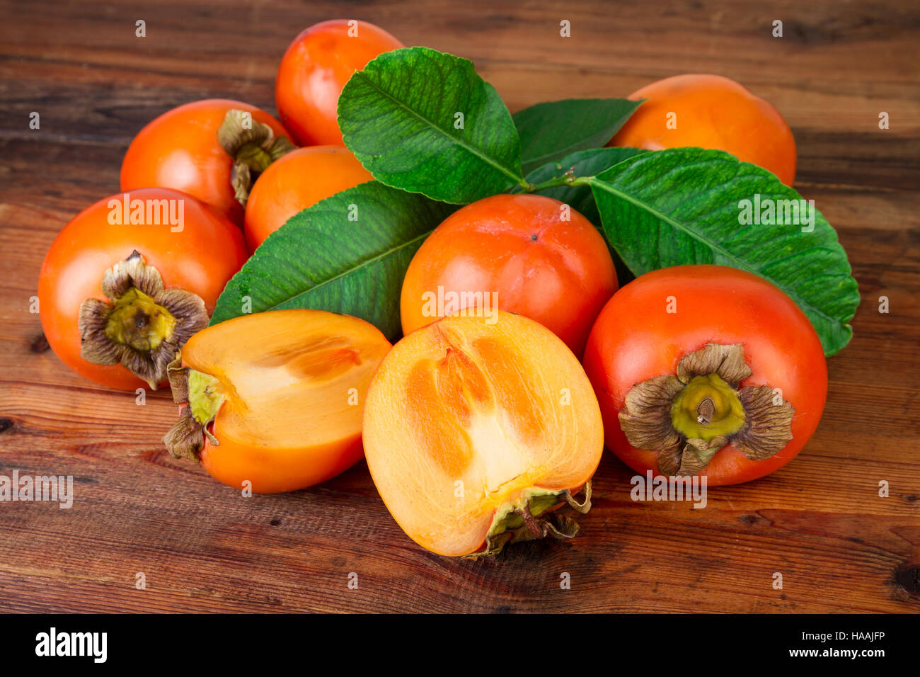 ripe persimmons kaki fruits on rustic background Stock Photo