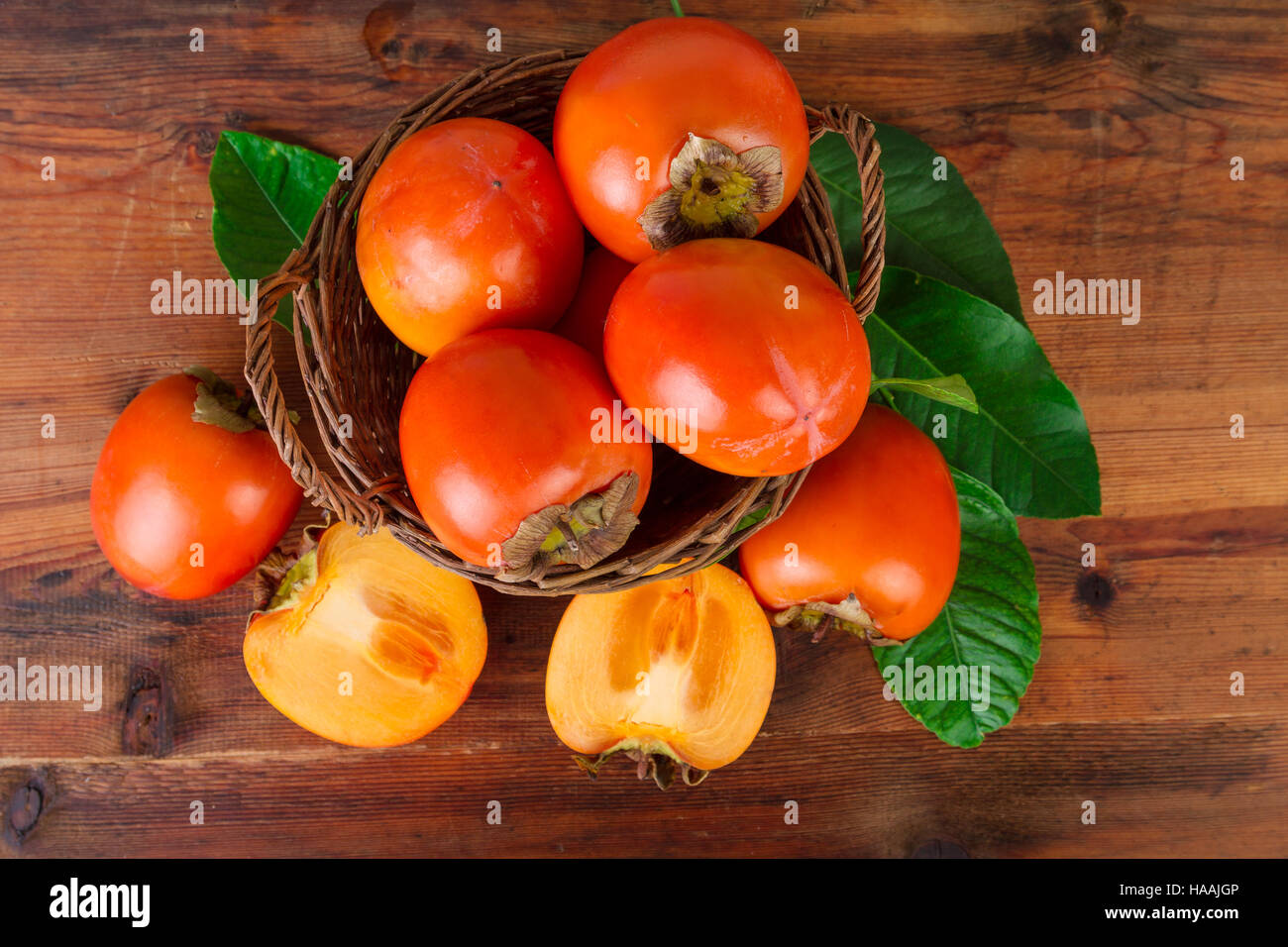 Persimmons on dark wood. Top view. Stock Photo