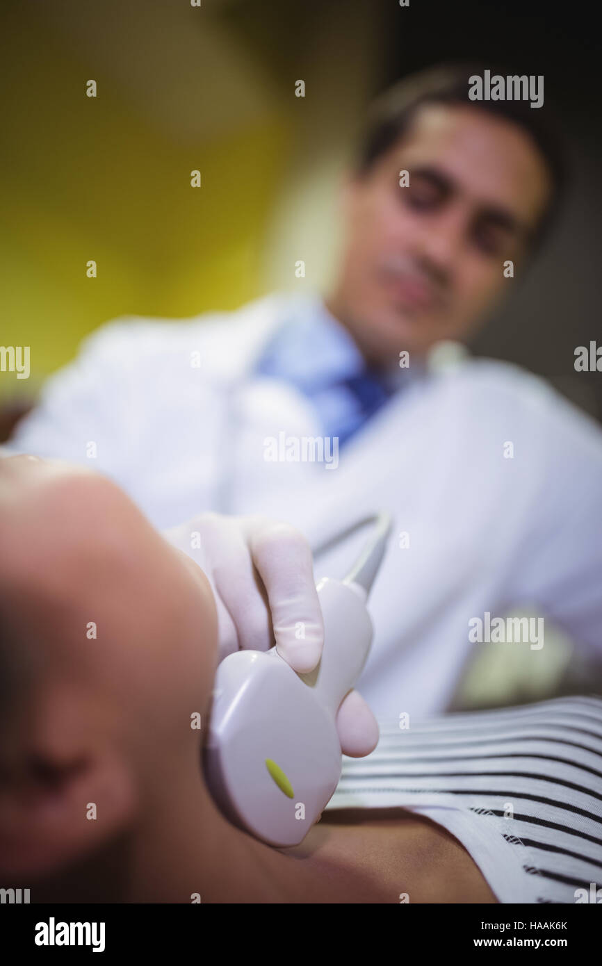 Female patient receivng a ultrasound  scan on the neck Stock Photo