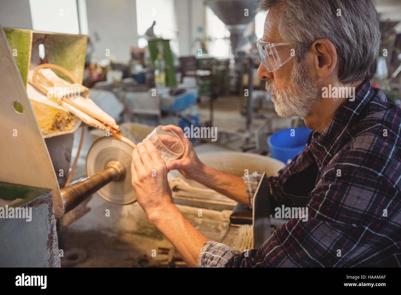 Glassblower polishing and grinding a glassware Stock Photo