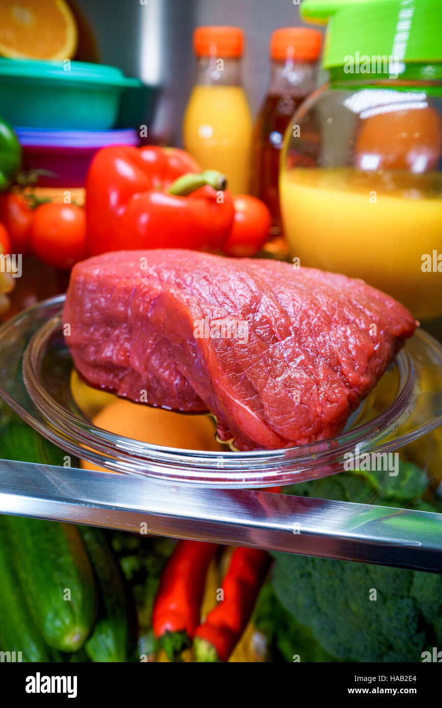 Fresh raw meat on a shelf open refrigerator Stock Photo