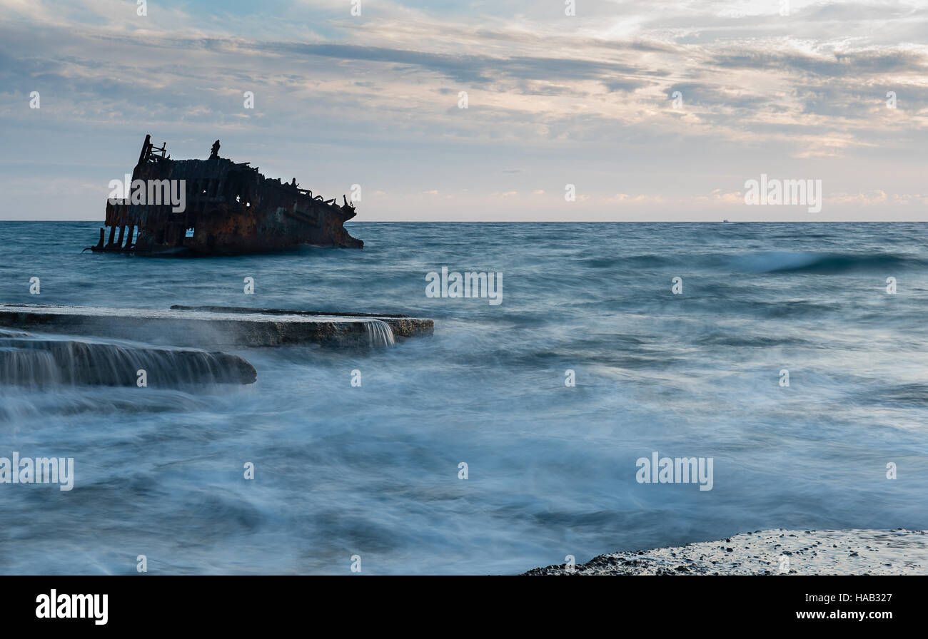 Shipwreck of an abandoned ship on a rocky coast at Akrotiri Beach in Cyprus Stock Photo