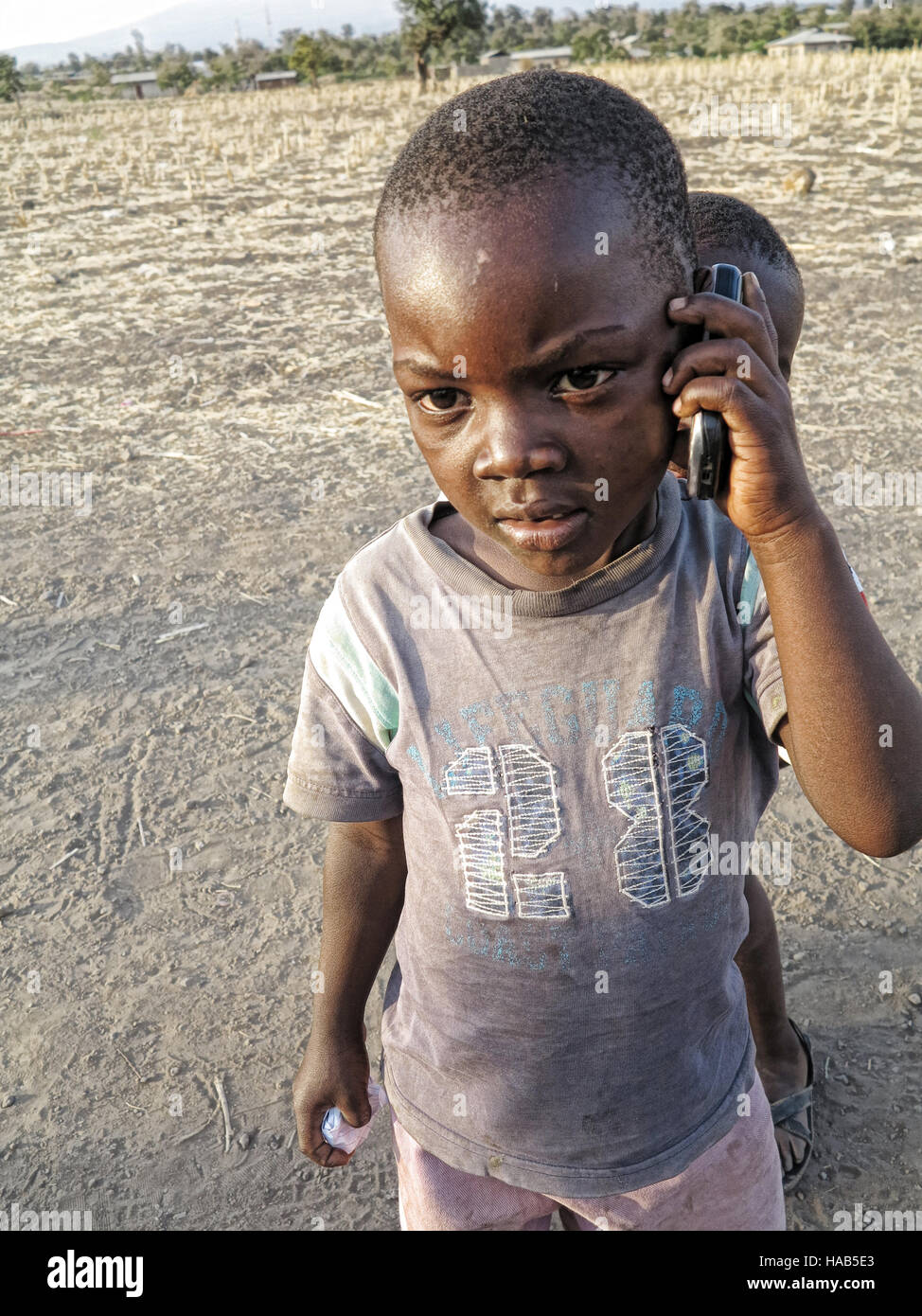 Young African boy on fake cell phone in Moshi Tanzania playing and