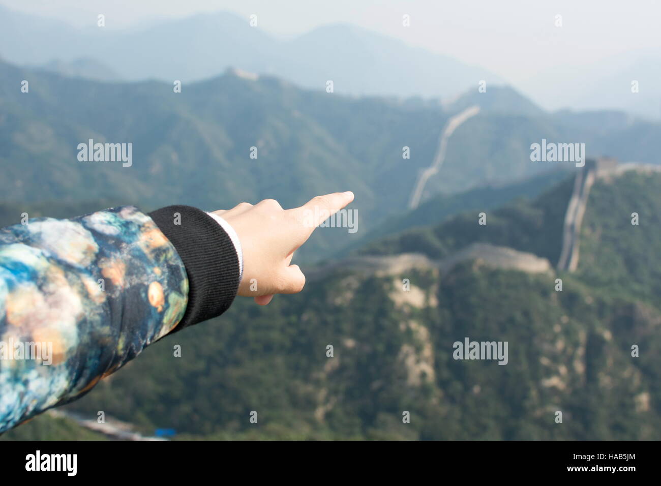 Female hand pointing the Great Wall of China, lets go there Stock Photo