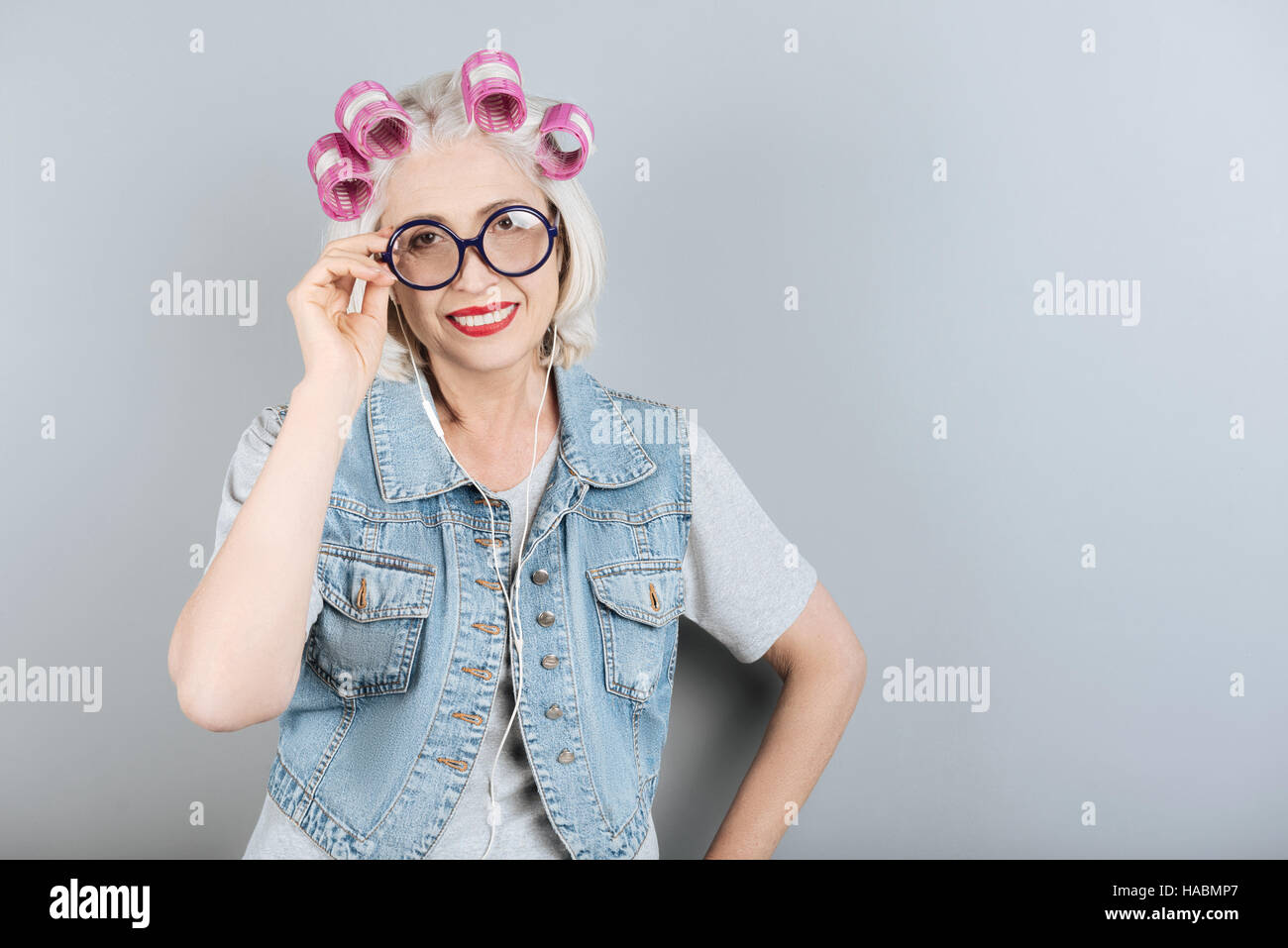 Smiling senior woman touching her glasses Stock Photo - Alamy