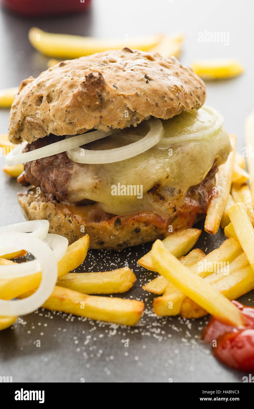 Homemade cheeseburger with french fries, onion slices Stock Photo