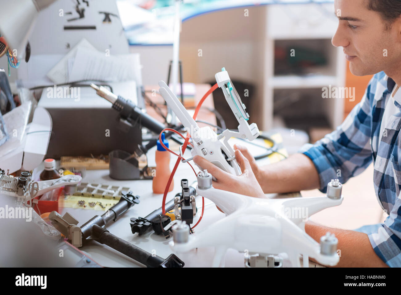 Young man putting together all drone details attentively Stock Photo ...