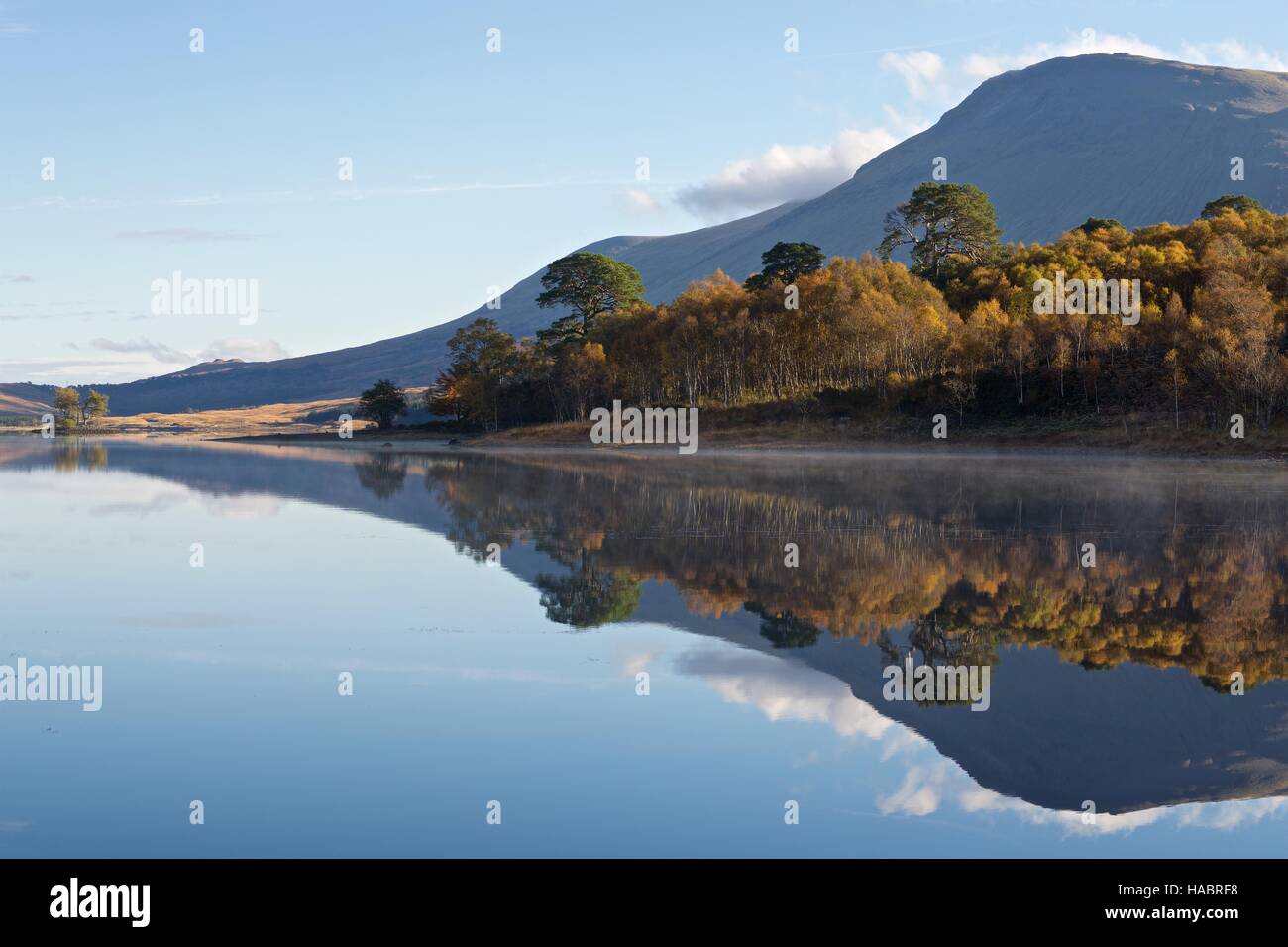 Clear reflections of the autumn colours and mountains in the still waters of Loch Tulla Stock Photo