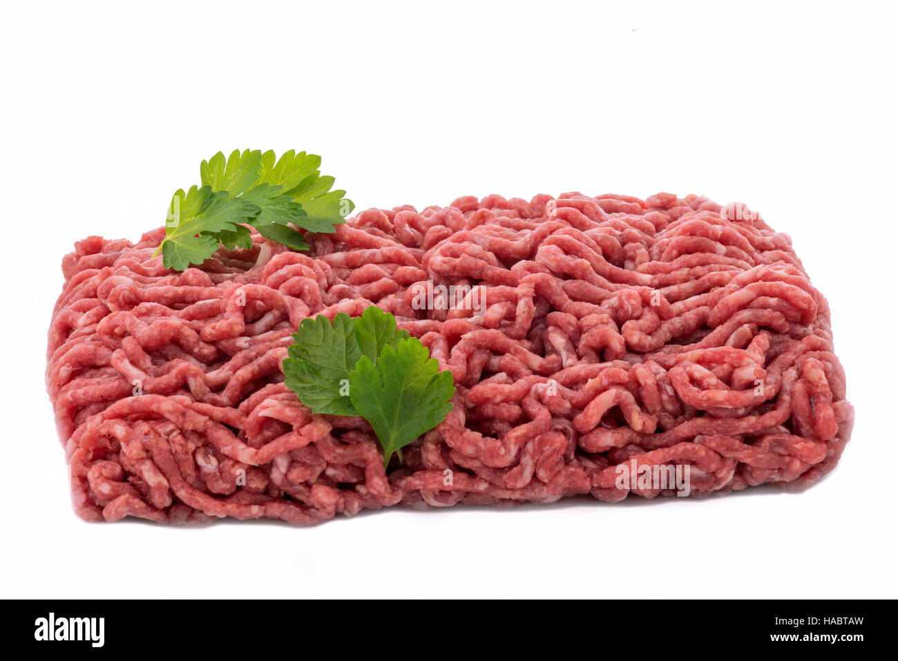 uncooked  minced meat with garnish on a white isolated background Stock Photo