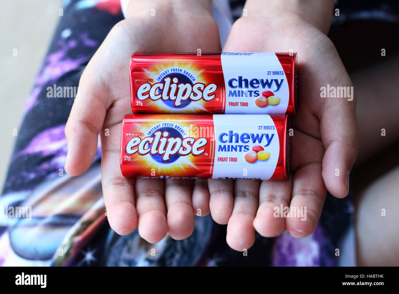 A child hand holding Australian Eclipse Chewy Mints Stock Photo