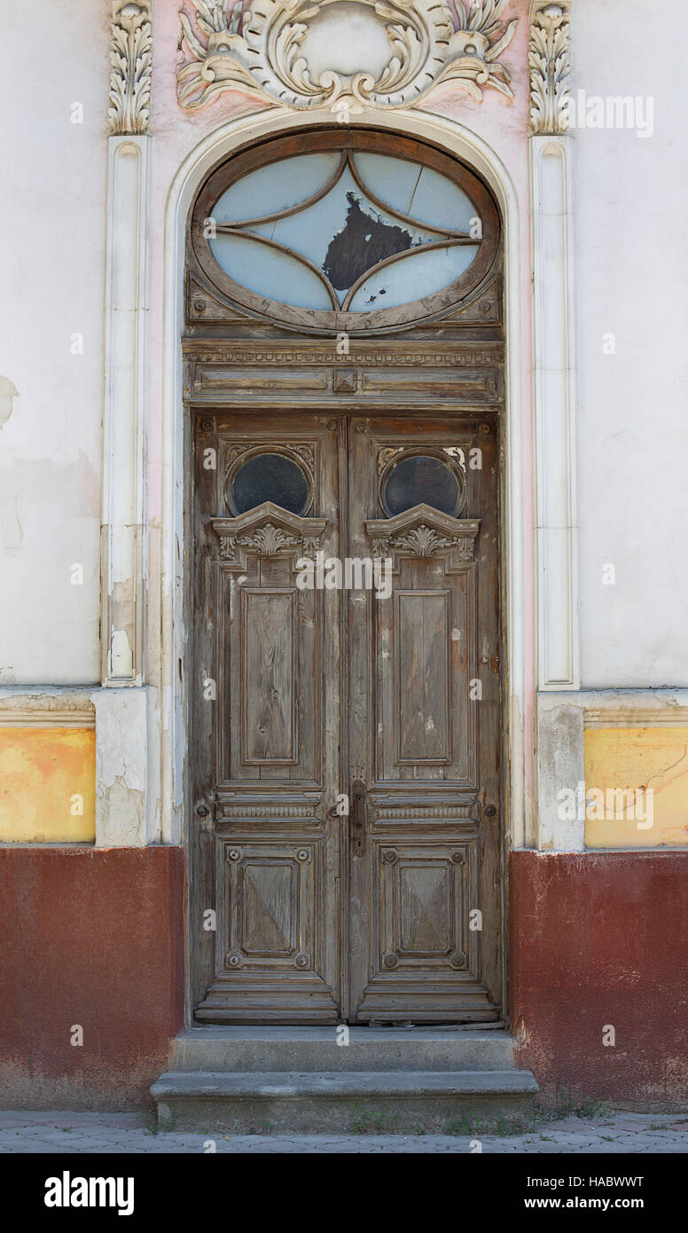 Brown old door on background of ancient house with stucco Stock Photo