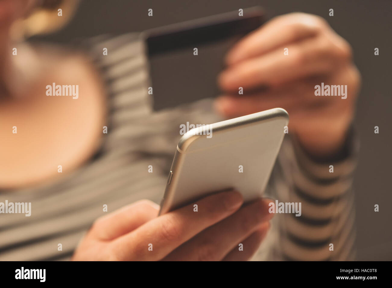 Woman using smartphone app to check e-wallet account balance, close up of hands with mobile phone and plastic credit card Stock Photo