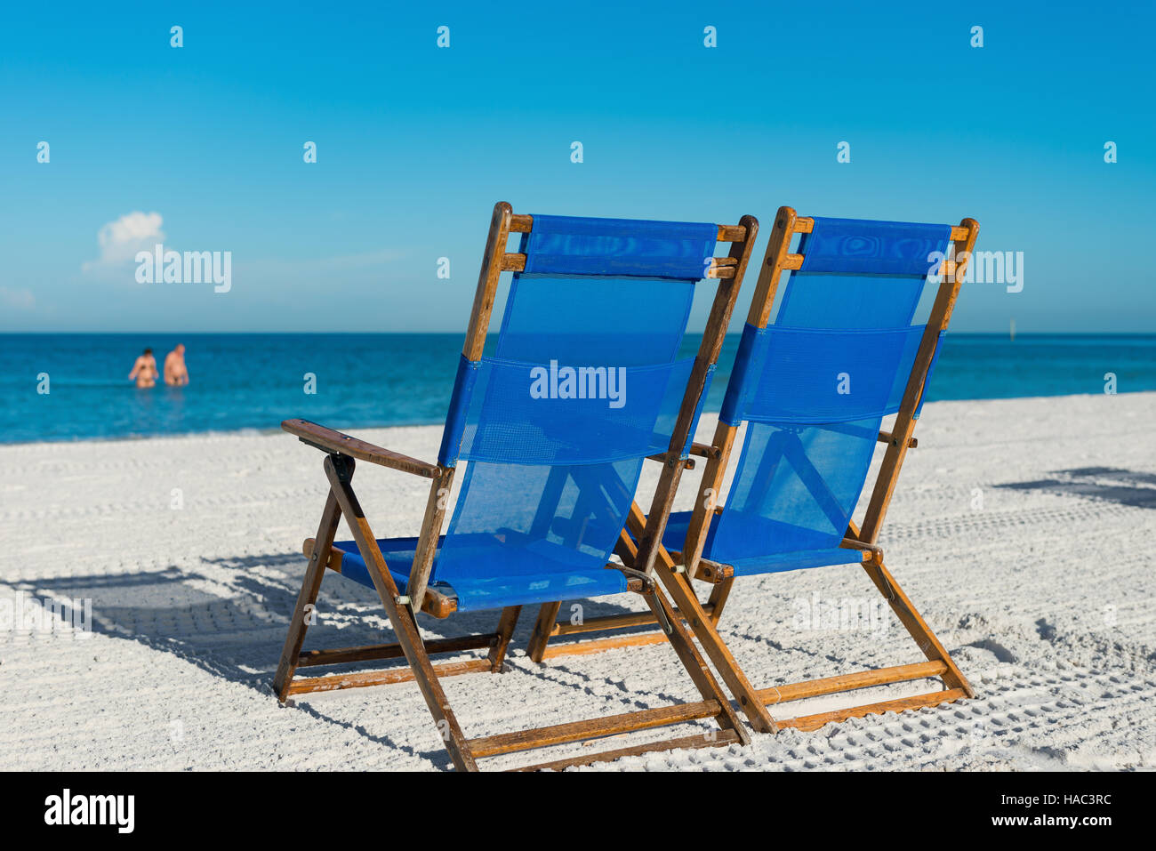 sun loungers on silver sand as  vacation concept Stock Photo