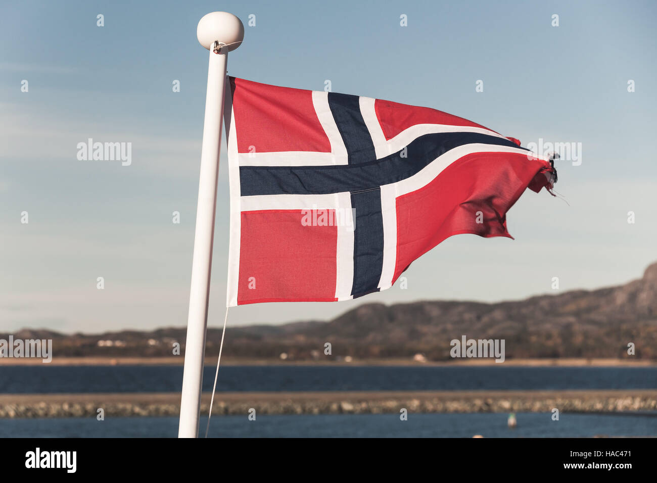 Norwegian national flag over blue sky background, vintage toned photo Stock Photo