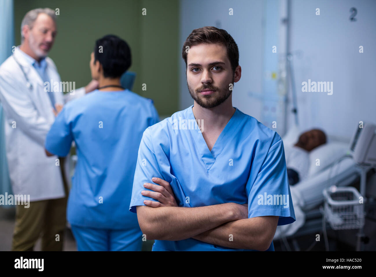 Portrait of male nurse standing in ward Stock Photo