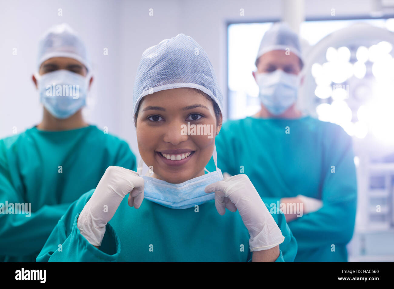 Team of surgeons wearing surgical mask in operation theater Stock Photo