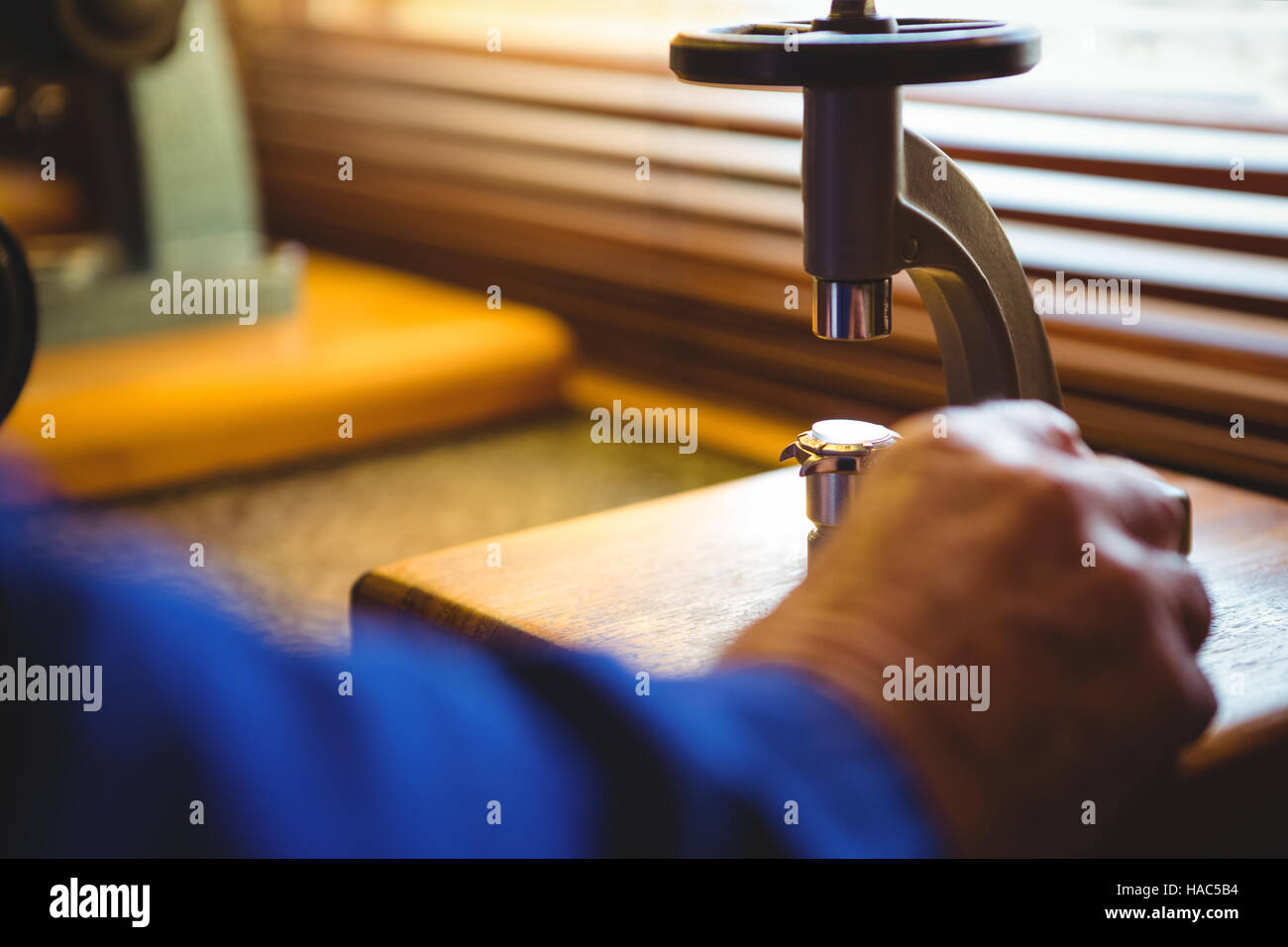 Hand of horologist using a microscope Stock Photo