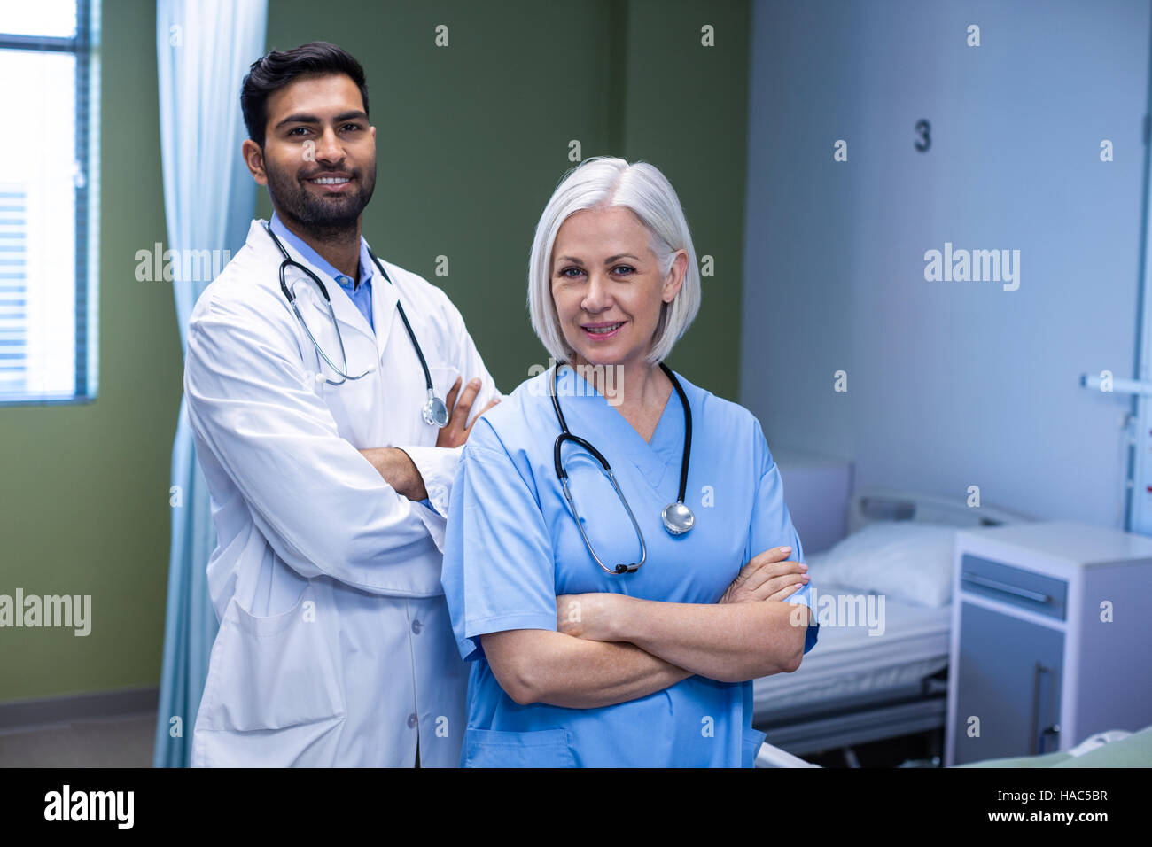 Doctor and nurse standing with arms crossed in hospital Stock Photo - Alamy