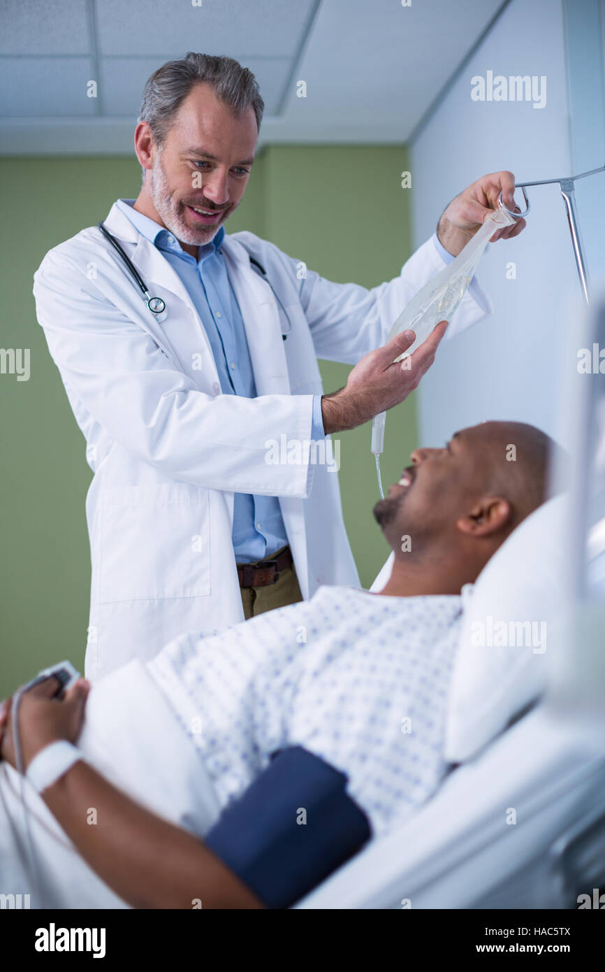 Doctor interacting with patient while adjusting iv drip Stock Photo - Alamy