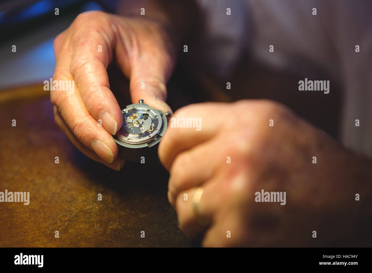 Horologist examining a clock part Stock Photo